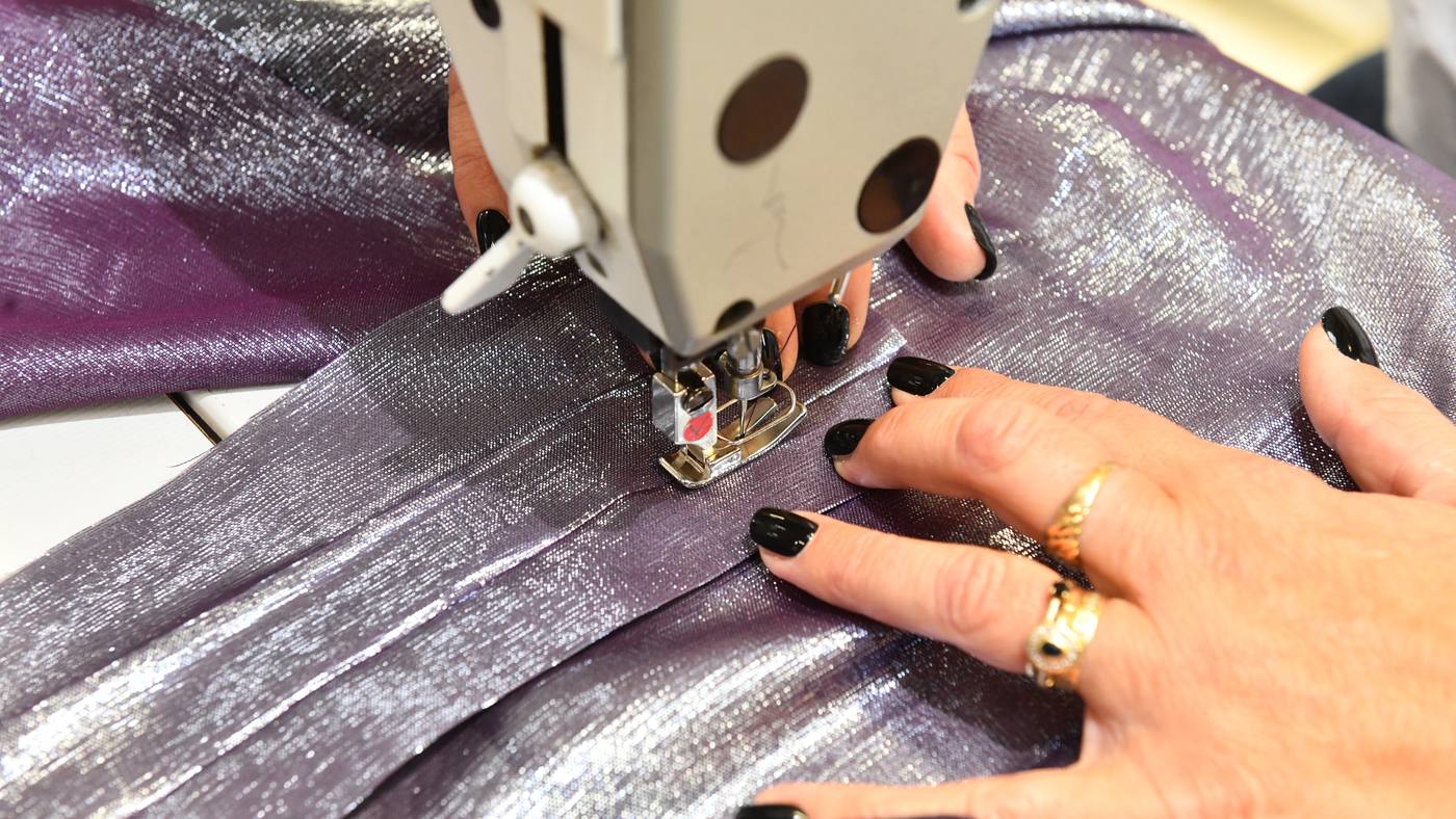 Mécanicienne au montage d'une pièce en tissu tissé