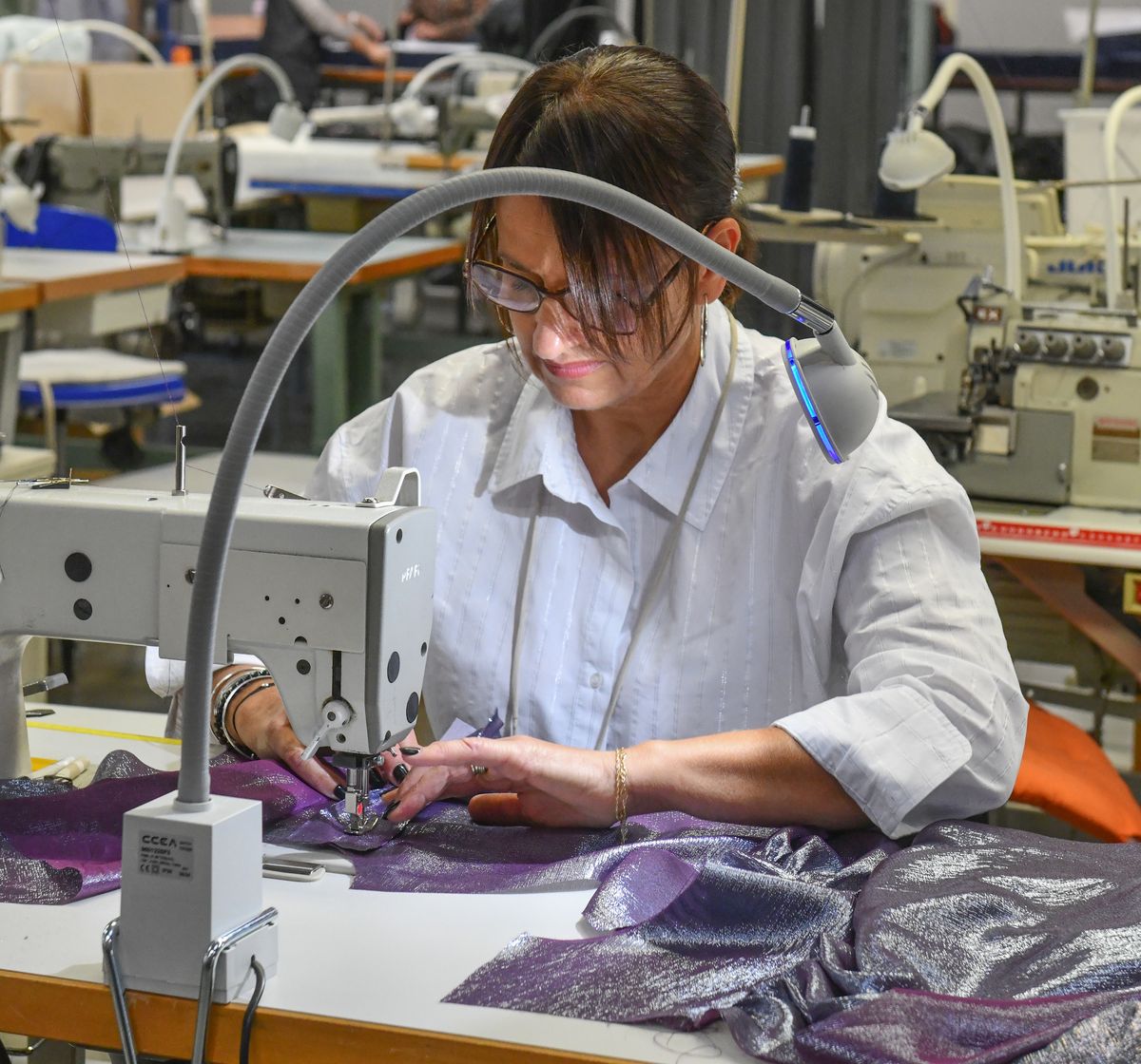 Mécanicienne au montage d’une pièce en tissu tissé